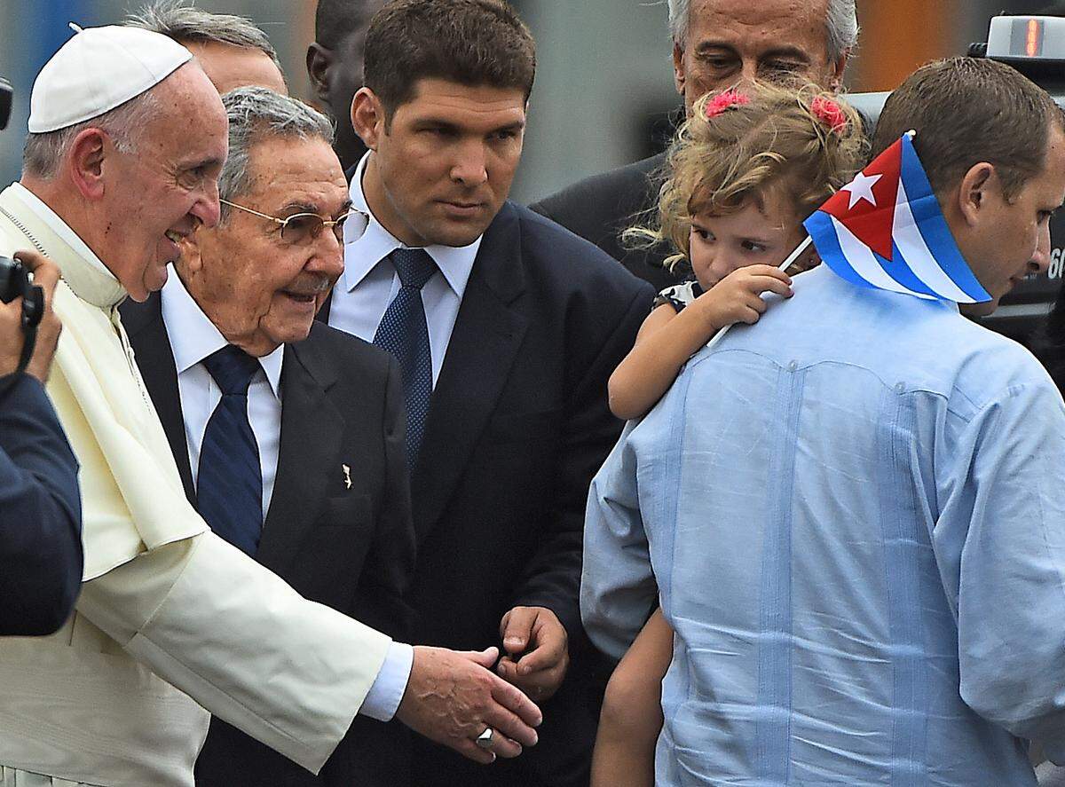 The late Pope Francis greets a girl next to Cuban President Raul Castro and Castro's bodyguard and grandson Raul Guillermo Rodriguez Castro (center) upon landing at Havana's international airport on Sept. 19, 2015.