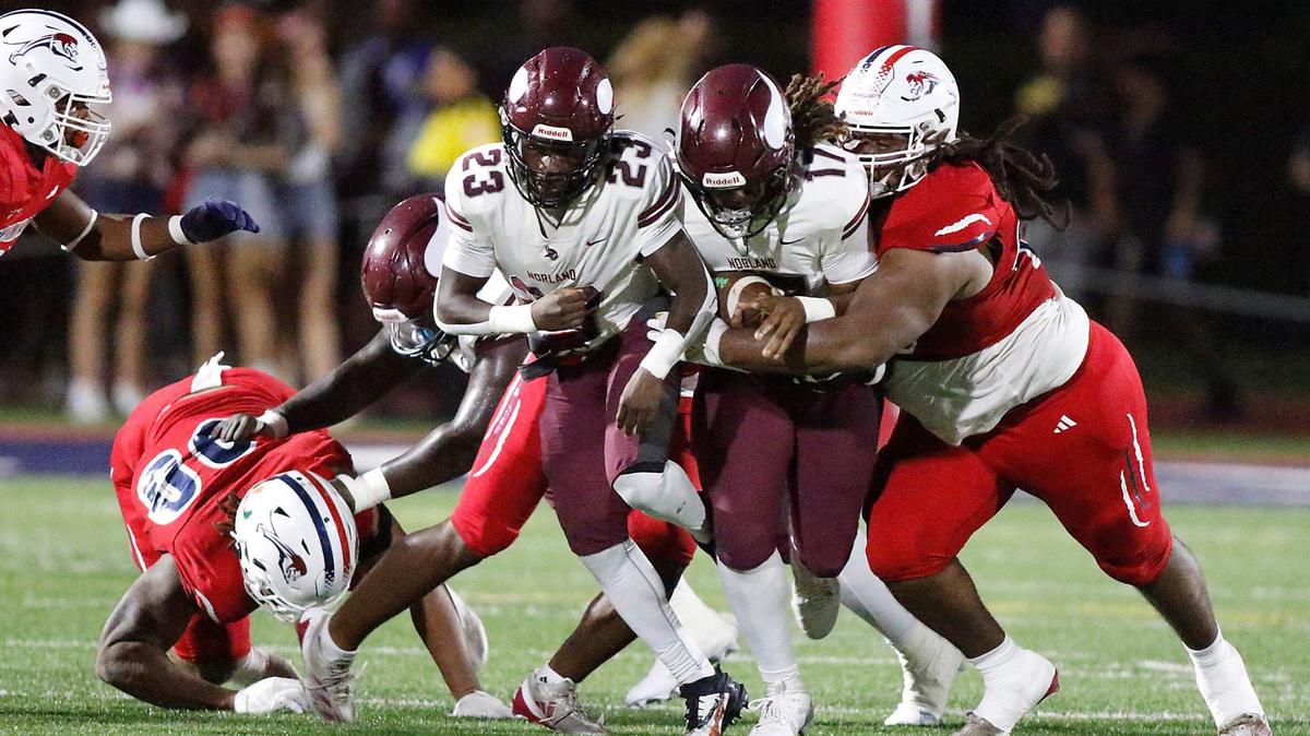 Chaminade-Madonna Lions defenders tackle Norland Vikings wide receiver Ennio Yapoor during football game on Thursday, September 19, 2024 at Chaminade-Madonna HS in Hollywood.