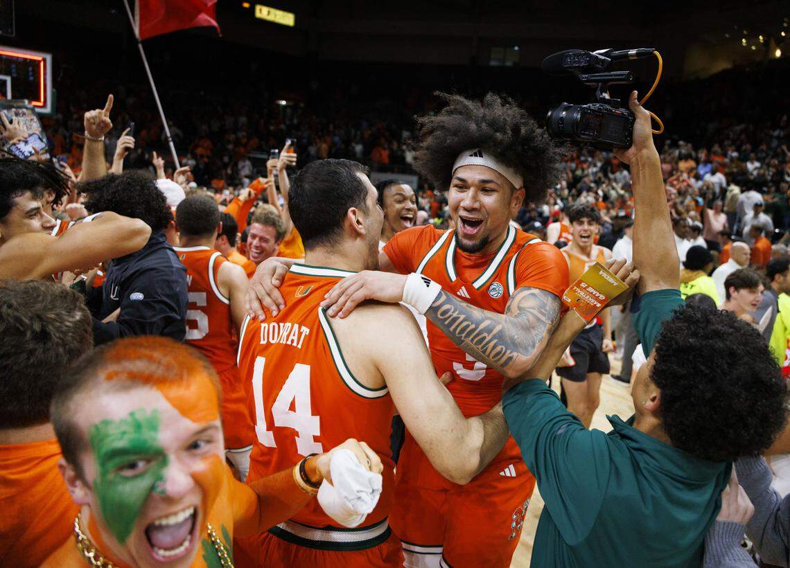 Miami Hurricanes guard Tre Donaldson (3) celebrates with guard Noam Dovrat (14) after fans stormed the court when the Miami Hurricanes beat the North Carolina Tar Heels 75-66 on Tuesday, Feb. 10, 2026, at the Watsco Center in Coral Gables, Fla.