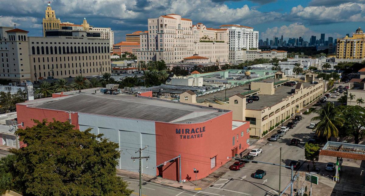 A bird’s eye view of downtown Coral Gables shows the side and back of Miracle Mile’s historic Art Deco Miracle Theater and, directly behind it on Andalusia Avenue, a two-story public parking structure that the city plans to replace with a massive and controversial contemporary garage, with rooftop terrace and ground floor retail. At top left is a city parking garage in the Gables’ traditional Mediterranean style.