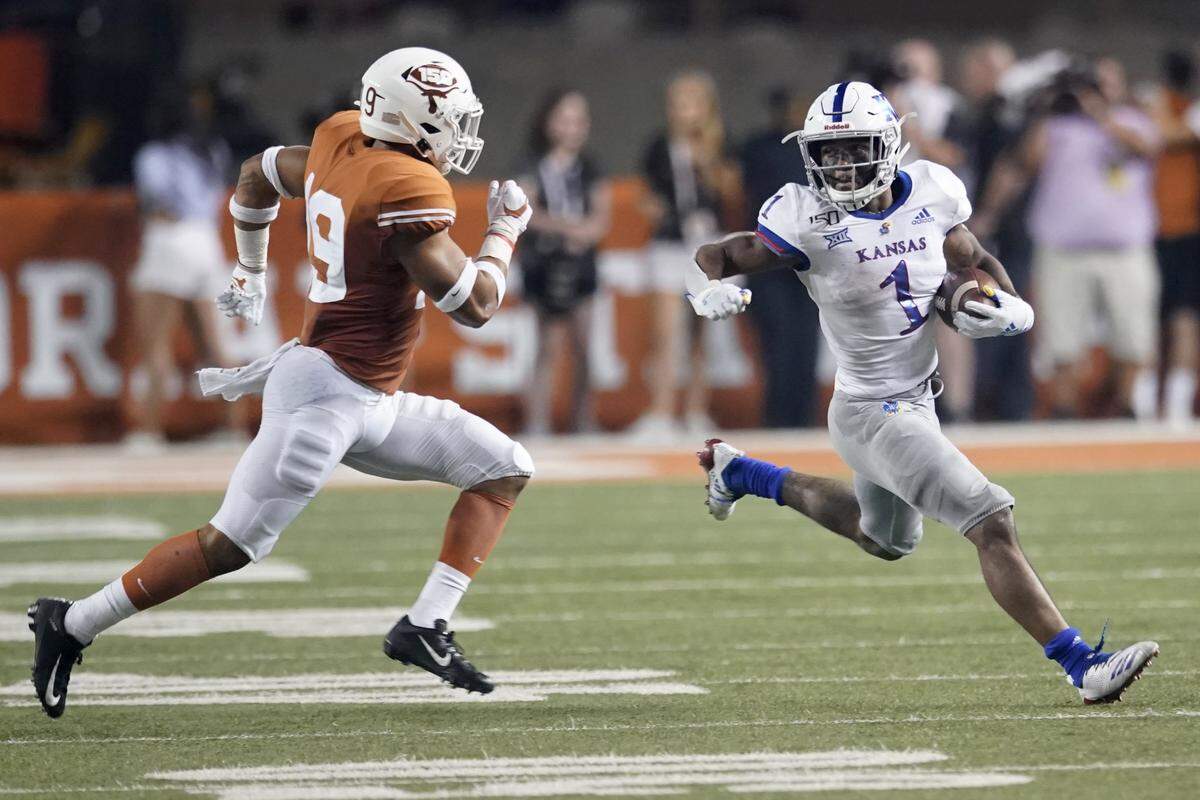 Kansas’ Pooka Williams Jr. (1) runs for a long gain as Brandon Jones (19) pursues during the second half of an NCAA college football game in Austin, Texas, Saturday, Oct. 19, 2019. (AP Photo/Chuck Burton)