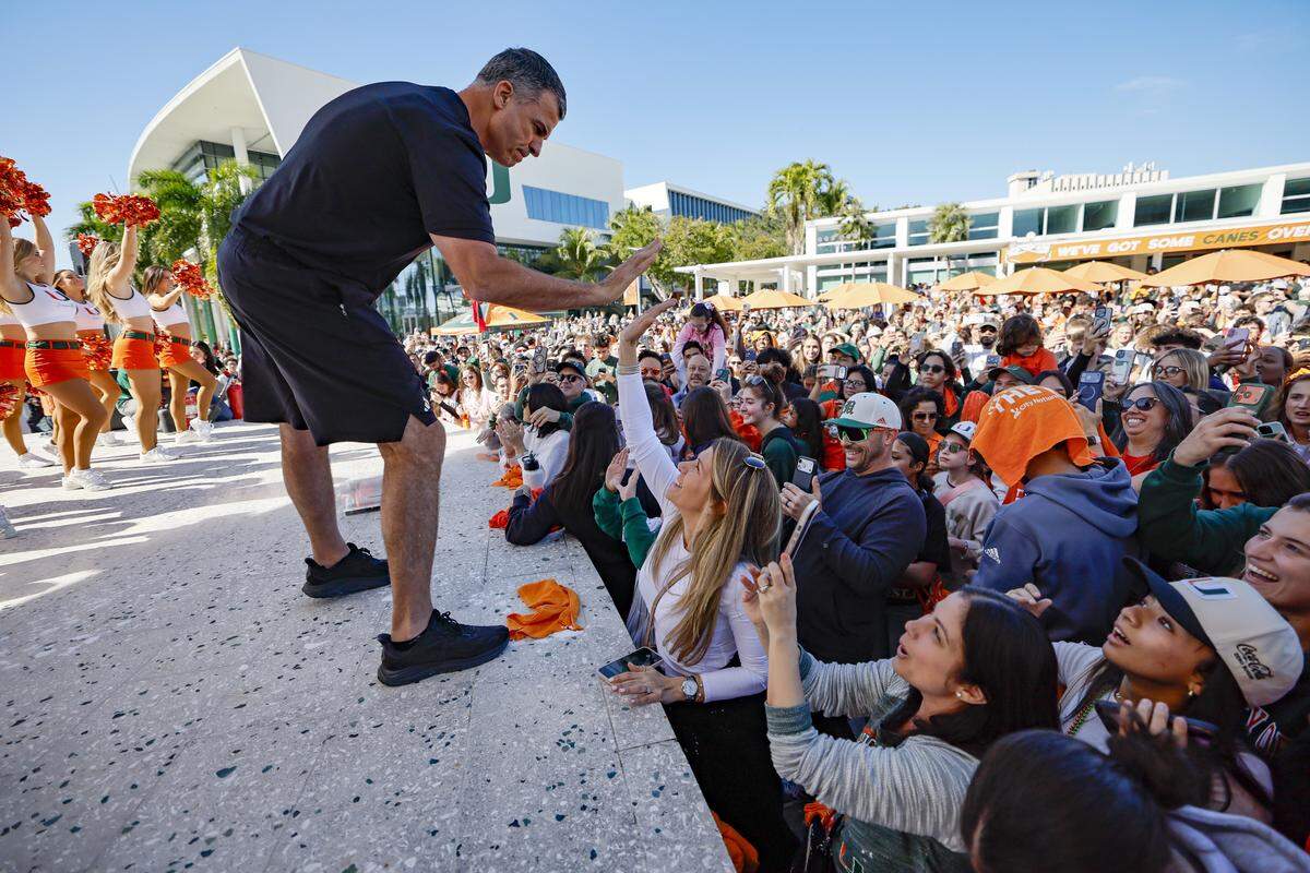 Miami Hurricanes head coach Mario Cristobal high-five fans attending the Miami Hurricanes pep rally.
