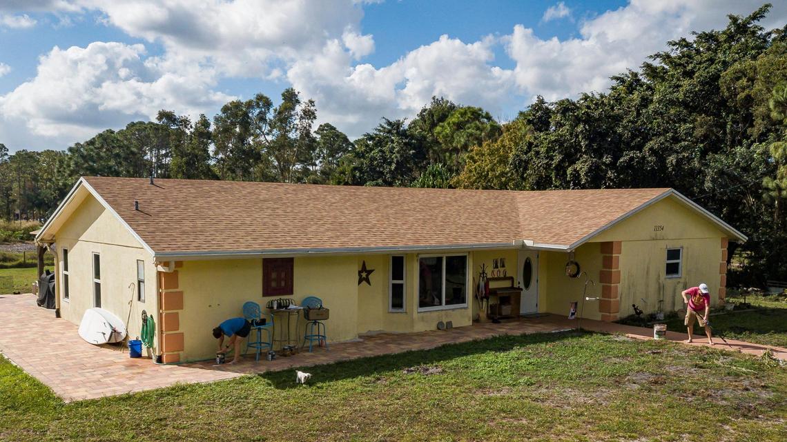 Aerial view shows Ray Coulter, 53, and his wife, Kelly Coulter, 44, working on home improvement projects on Wednesday, Jan. 31, 2023, in West Palm Beach, Fla. The Coulters used Ygrene funding to finance a brand new roof and impact windows before Ygrene yanked the financing for everyone in Florida.
