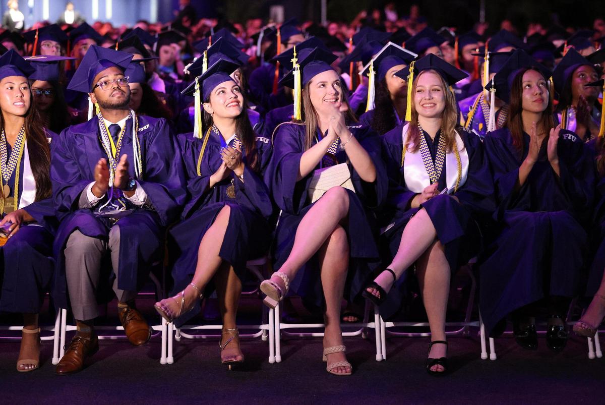 Attentive students sit on the front row at a graduation ceremony at the Ocean Bank Convention Center at the Modesto A. Maidique Campus on Sunday, April 30, 2023.