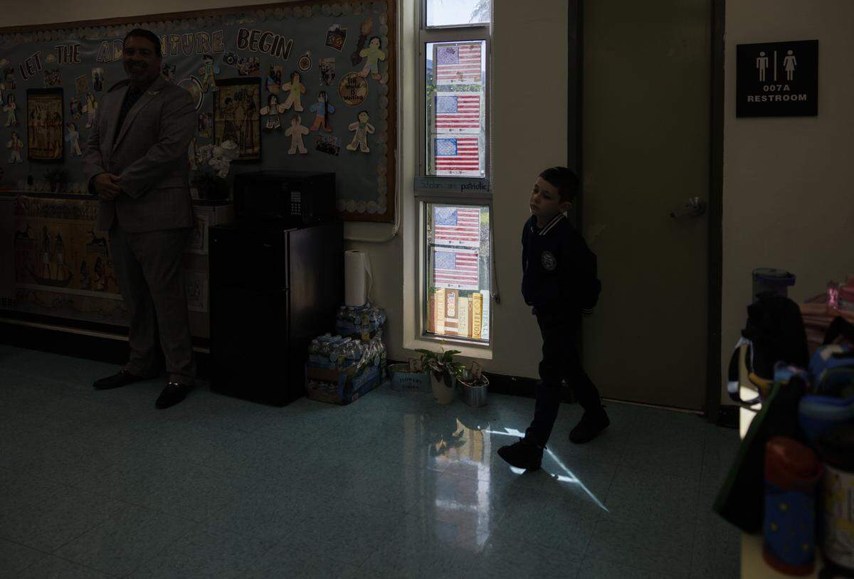 A student walks passed American flags they made in the Kindergarten classical education classroom of Ms. Geraldine Cameron listen during the school day on Tuesday, Nov. 18, 2025, at Village Green Elementary School in Miami, Fla. Cameron has helped to implement a classical education system at the school that originates from Ancient Greece meant to cultivate critical thinking and virtues in its students, and it disconnects them from technology to focus on active listening.