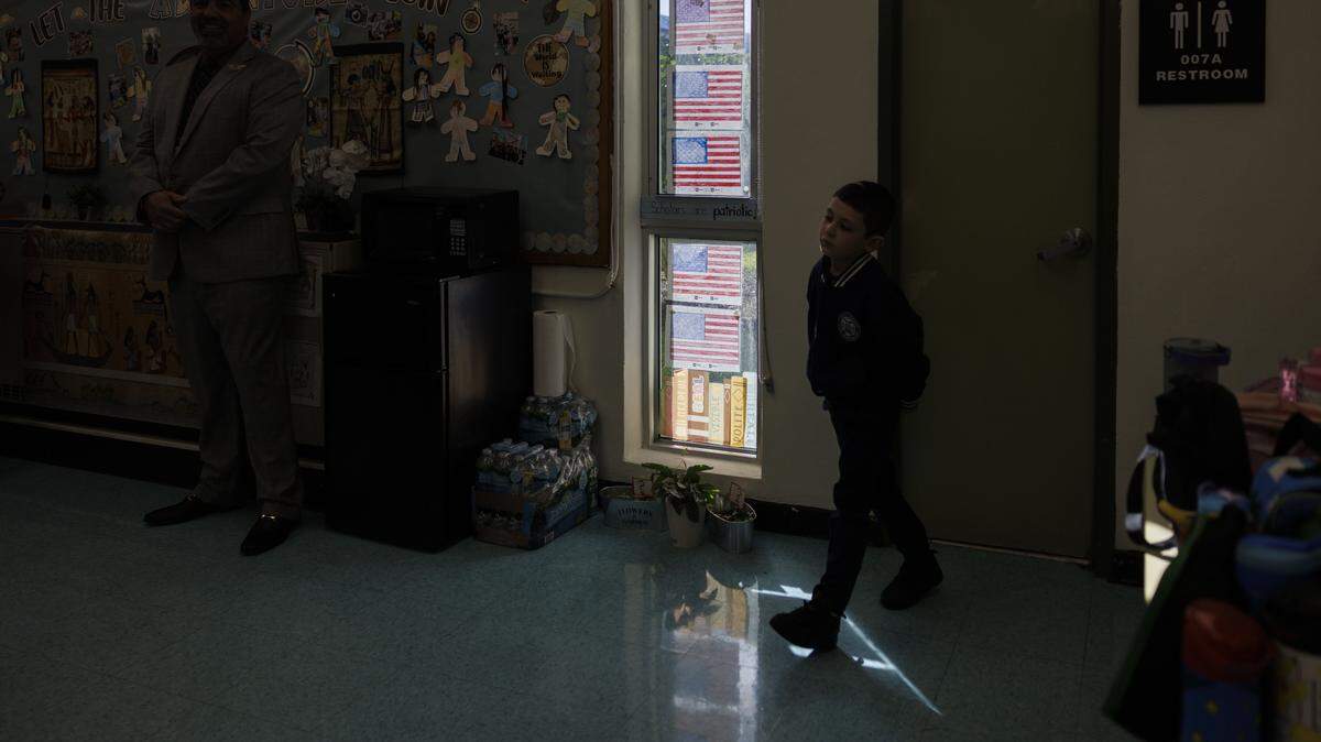 A student walks passed American flags they made in the Kindergarten classical education classroom of Ms. Geraldine Cameron listen during the school day on Tuesday, Nov. 18, 2025, at Village Green Elementary School in Miami, Fla. Cameron has helped to implement a classical education system at the school that originates from Ancient Greece meant to cultivate critical thinking and virtues in its students, and it disconnects them from technology to focus on active listening.