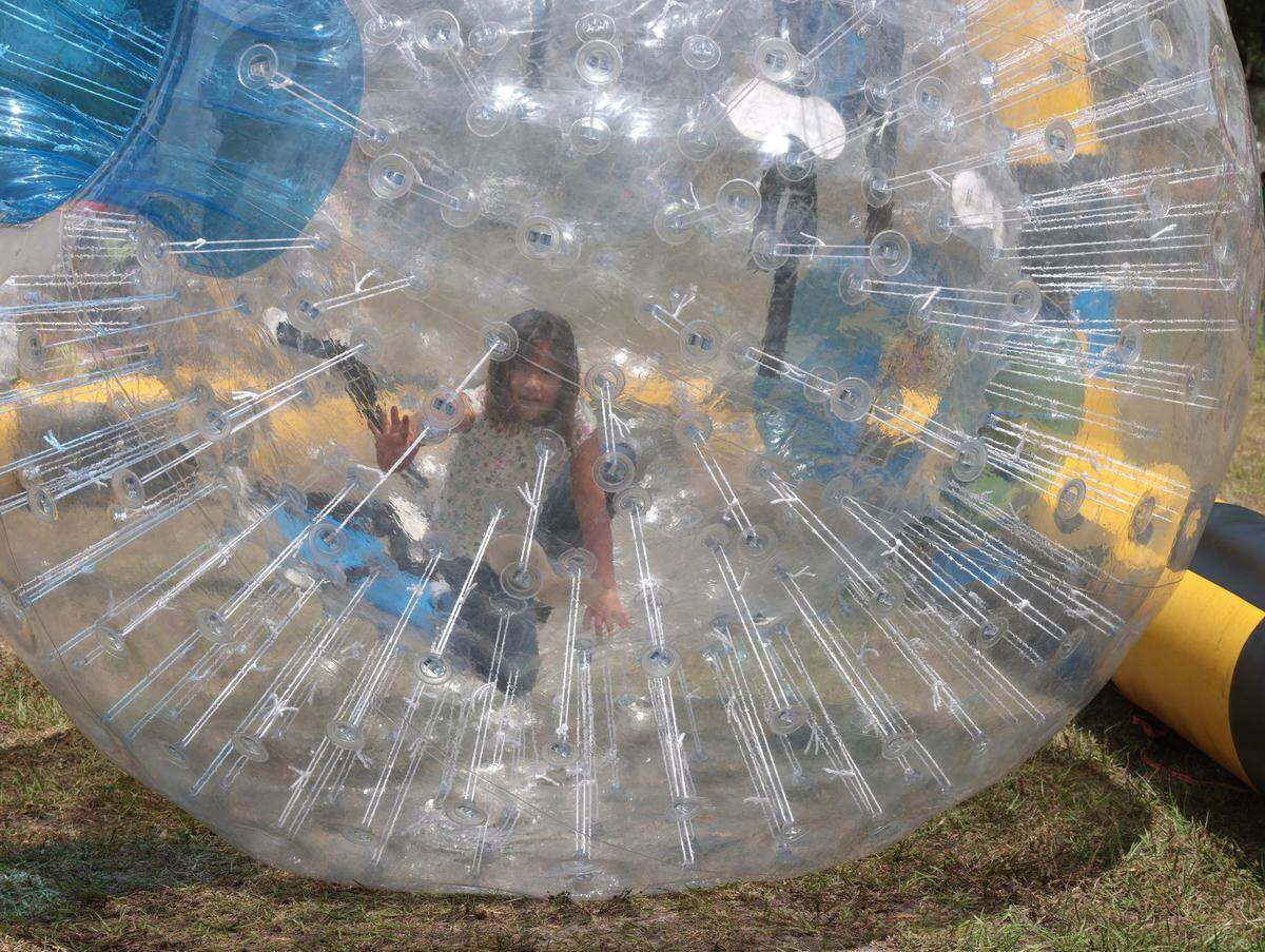 Mariana Moriones, 7, navigates the bubble ball through the course at the Kid Zone at the Miami Gardens Easter Day Eggstravaganza on Sunday, April 17, 2022.