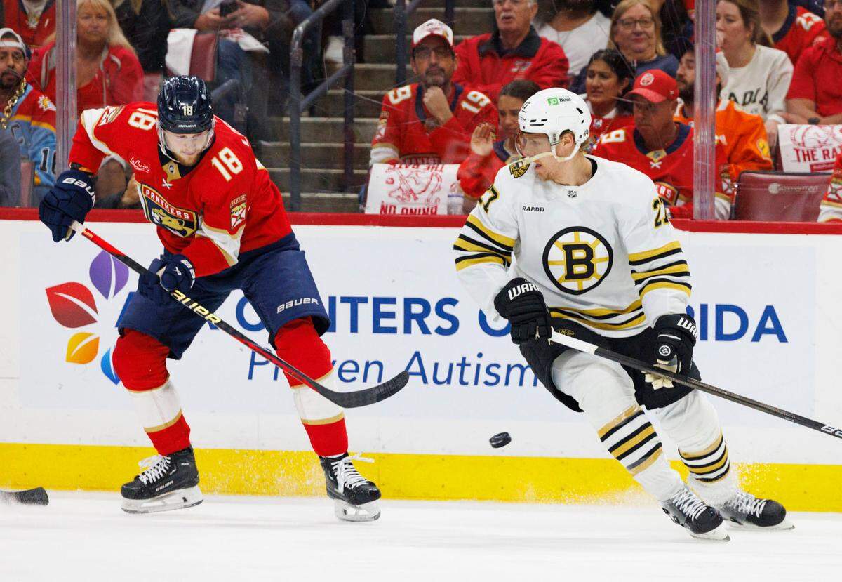 Florida Panthers center Steven Lorentz (18) hits the puck around Boston Bruins defenseman Hampus Lindholm (27) during the first period of Game 5 of a second-round Stanley Cup Playoff series on Tuesday, May 14, 2024, at Amerant Bank Arena in Sunrise, Fla.