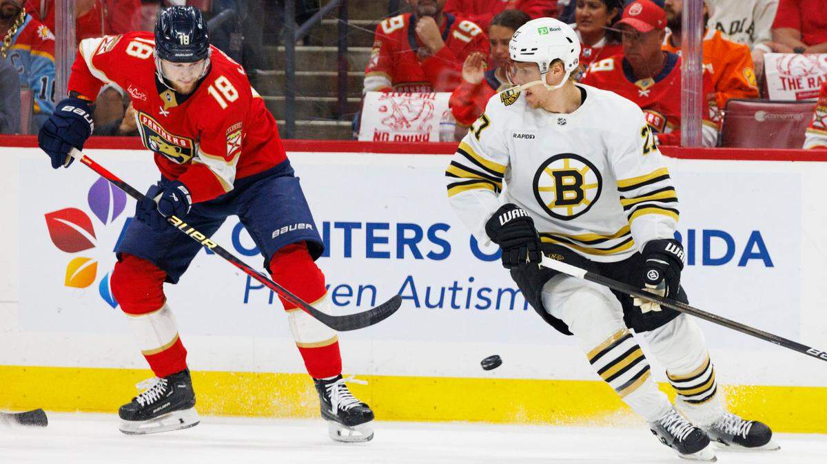 Florida Panthers center Steven Lorentz (18) hits the puck around Boston Bruins defenseman Hampus Lindholm (27) during the first period of Game 5 of a second-round Stanley Cup Playoff series on Tuesday, May 14, 2024, at Amerant Bank Arena in Sunrise, Fla.