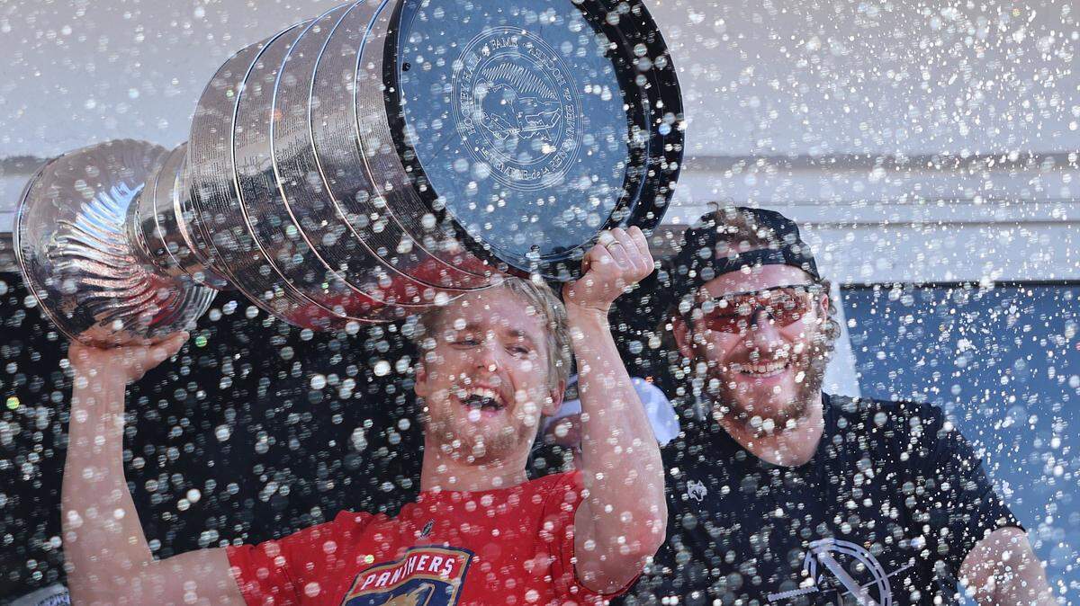 Gustav Forsling, left, raises the Stanley Cup as he and Matthew Tkachuk, right, celebrate in a haze of bubbles .