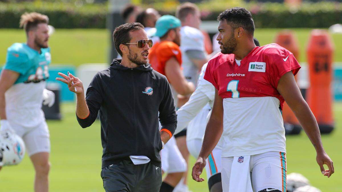 Miami Dolphins quarterback Tua Tagovailoa (1) and coach Mike McDaniel talk during practice at Baptist Health Training Complex in Miami Gardens on Wednesday, August 17, 2022.