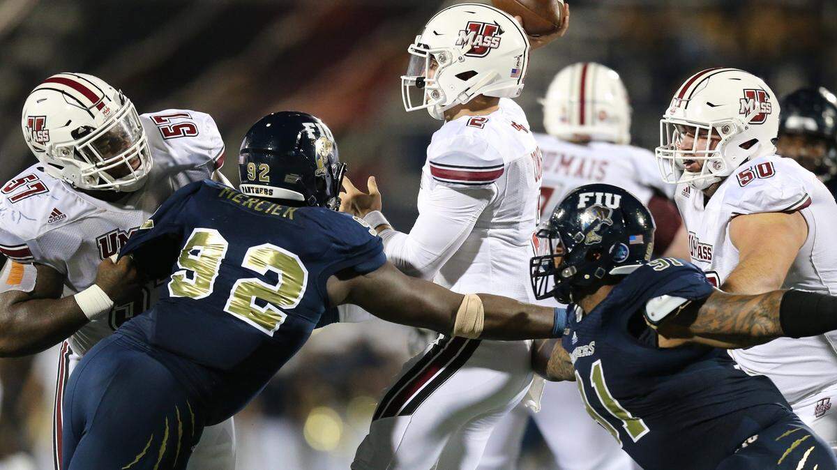 Massachusetts Minutemen quarterback Ross Comis (2) throws an incomplete pass as FIU’s Jason Mercier (92) rushes the quarterback on Sept. 15, 2018.