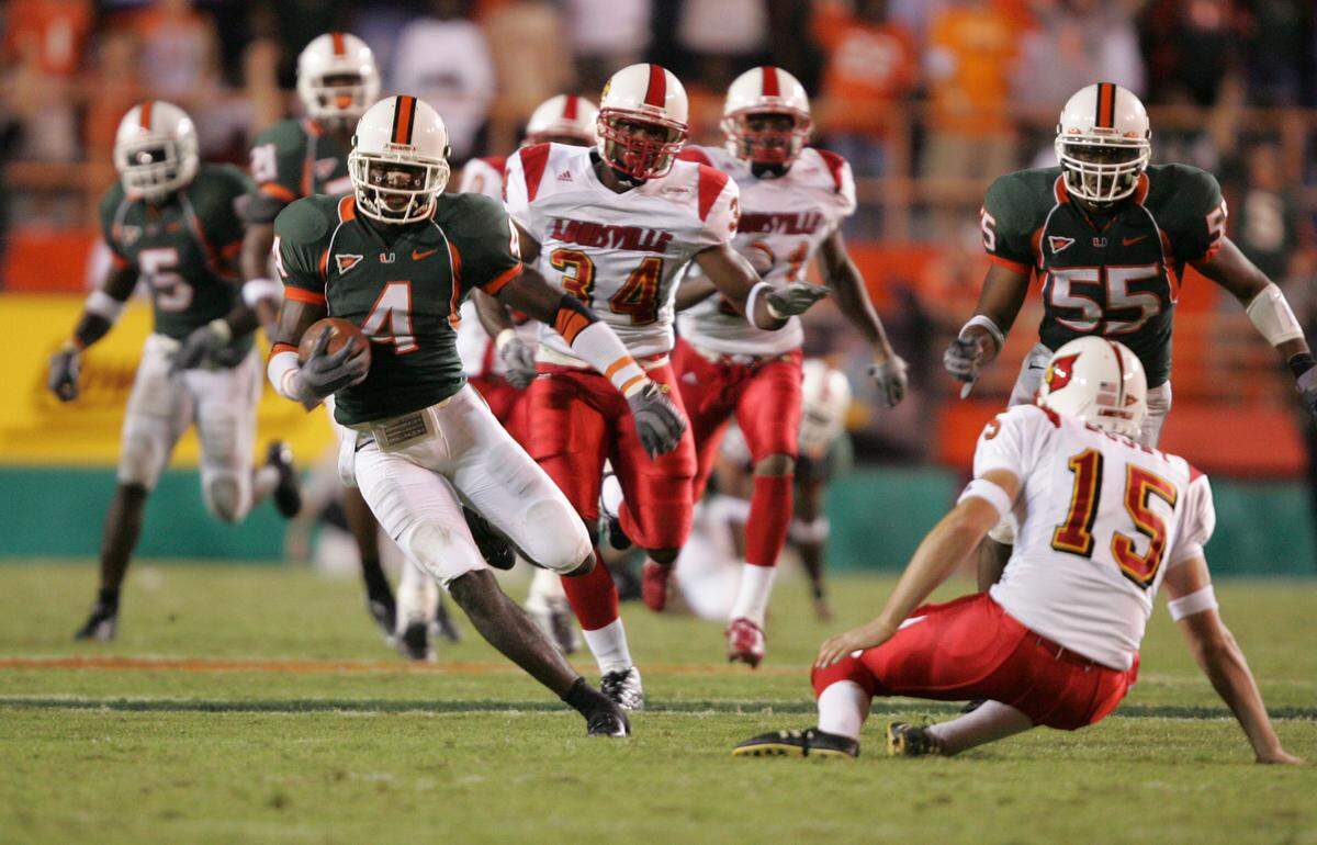 10/14/04--Al Diaz/Miami Herald Staff--Miami--Louisville vs the University of Miami at the Orange Bowl. UM’s Devin Hester jukes Louisville’s punter Brent Moody on his way to score on a punt return in the fourth quarter.