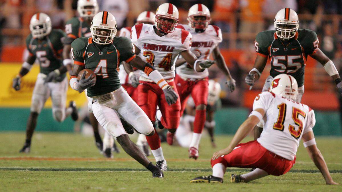 10/14/04--Al Diaz/Miami Herald Staff--Miami--Louisville vs the University of Miami at the Orange Bowl. UM’s Devin Hester jukes Louisville’s punter Brent Moody on his way to score on a punt return in the fourth quarter.