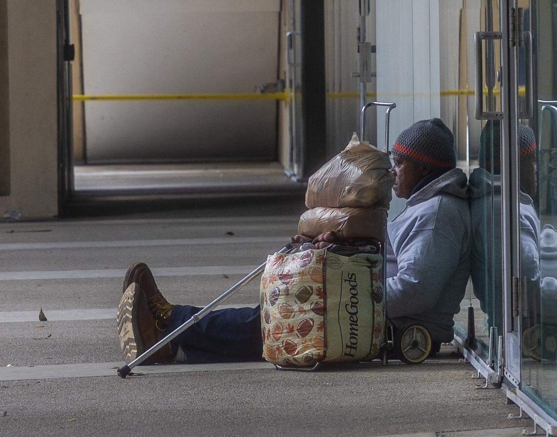 A man sits in downtown Miami near the Stephen P. Clark Center on Jan. 31, 2026.