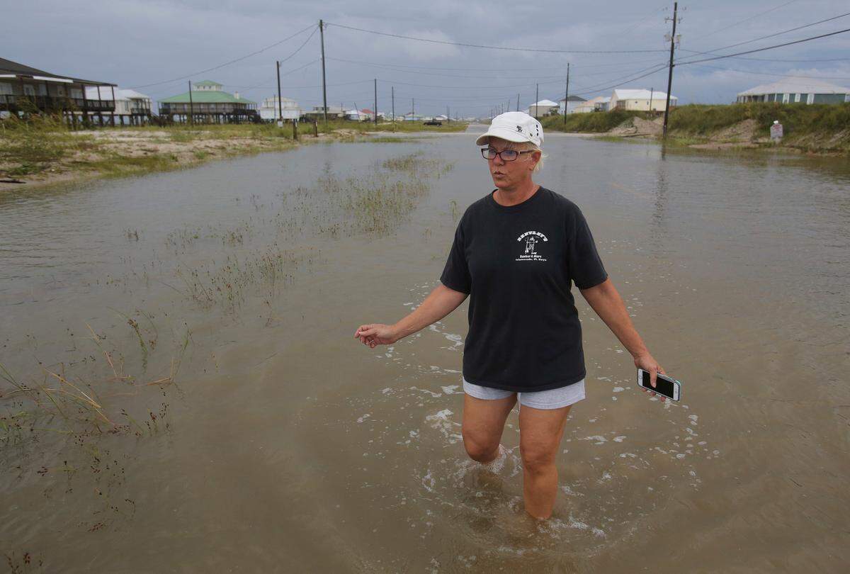 Susan Jones walks through a flooded road from Tropical Storm Gordon on Dauphin Island, Ala., on Wednesday. (AP Photo/Dan Anderson)