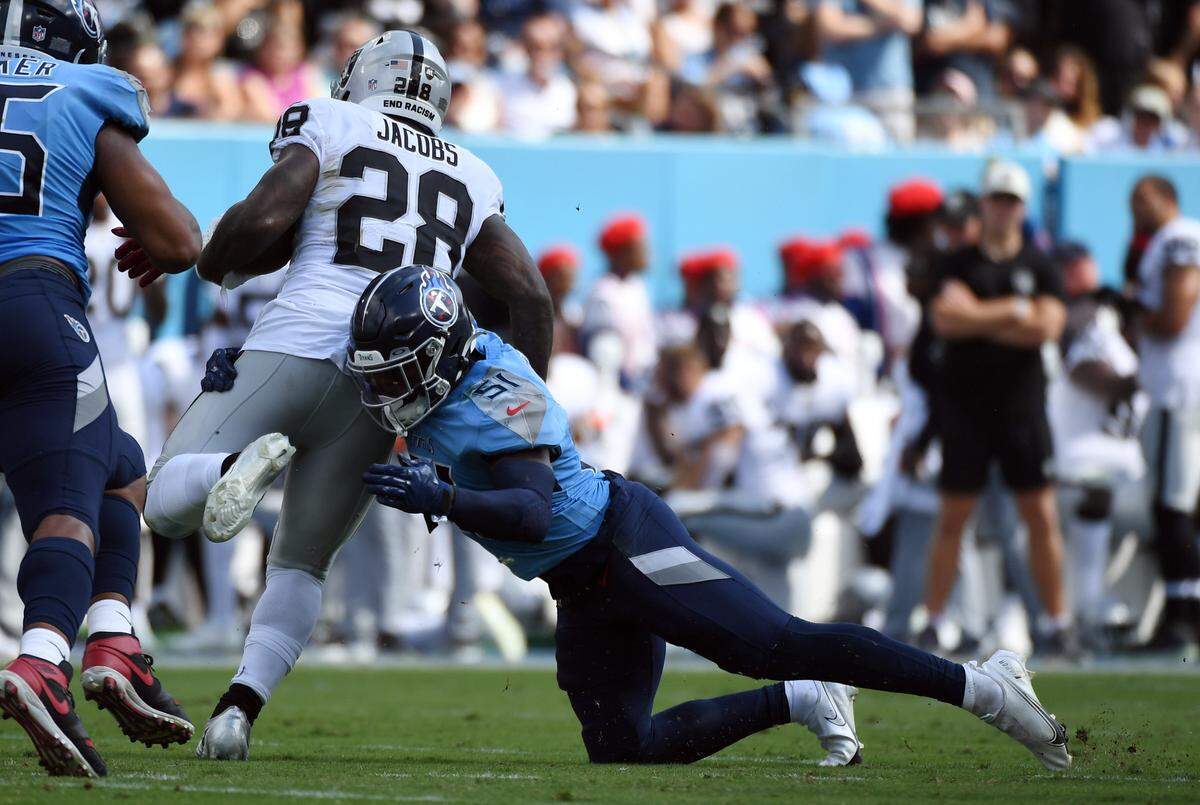 Sep 25, 2022; Nashville, Tennessee, USA; Las Vegas Raiders running back Josh Jacobs (28) is tackled by Tennessee Titans linebacker David Long Jr. (51) after a short gain during the first half at Nissan Stadium. Mandatory Credit: Christopher Hanewinckel-USA TODAY Sports