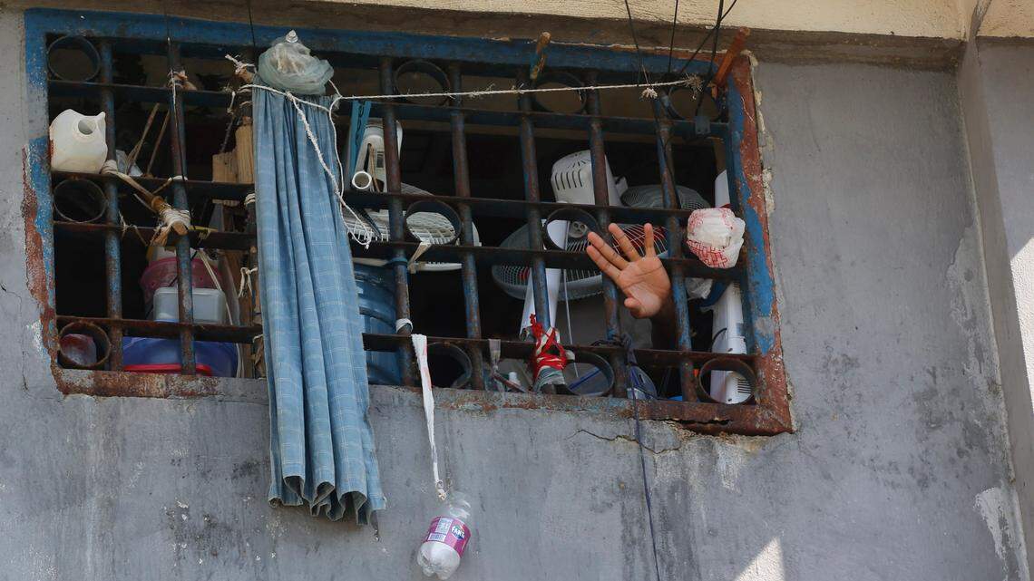 An inmate waves at the National Penitentiary in Port-au-Prince, Haiti, Sunday, March 3, 2024. Hundreds of inmates have fled Haiti’s main prison after armed gangs stormed the facility overnight.