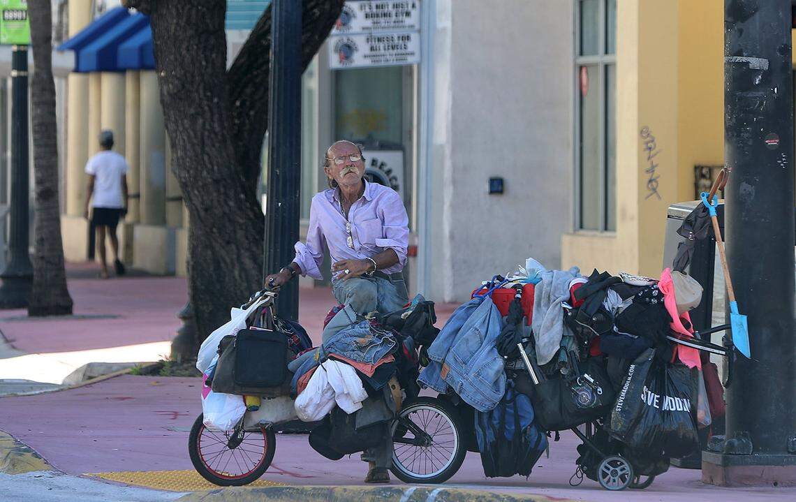 Johnny, who has lived on the streets for 20 years, keeps his belongings on a car latched to bike as he travels along Washington Avenue in Miami Beach. Advocates for the homeless population are working to prevent the spread of COVID-19 among the homeless population.