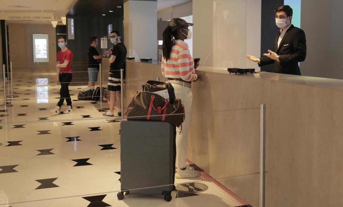 Miami Beach, Florida, June 1, 2020- Latoya Ruckner, from Detroit, Michigan, wearing the striped shirt, at the front desk checks in at the Fontainebleau Miami Beach.