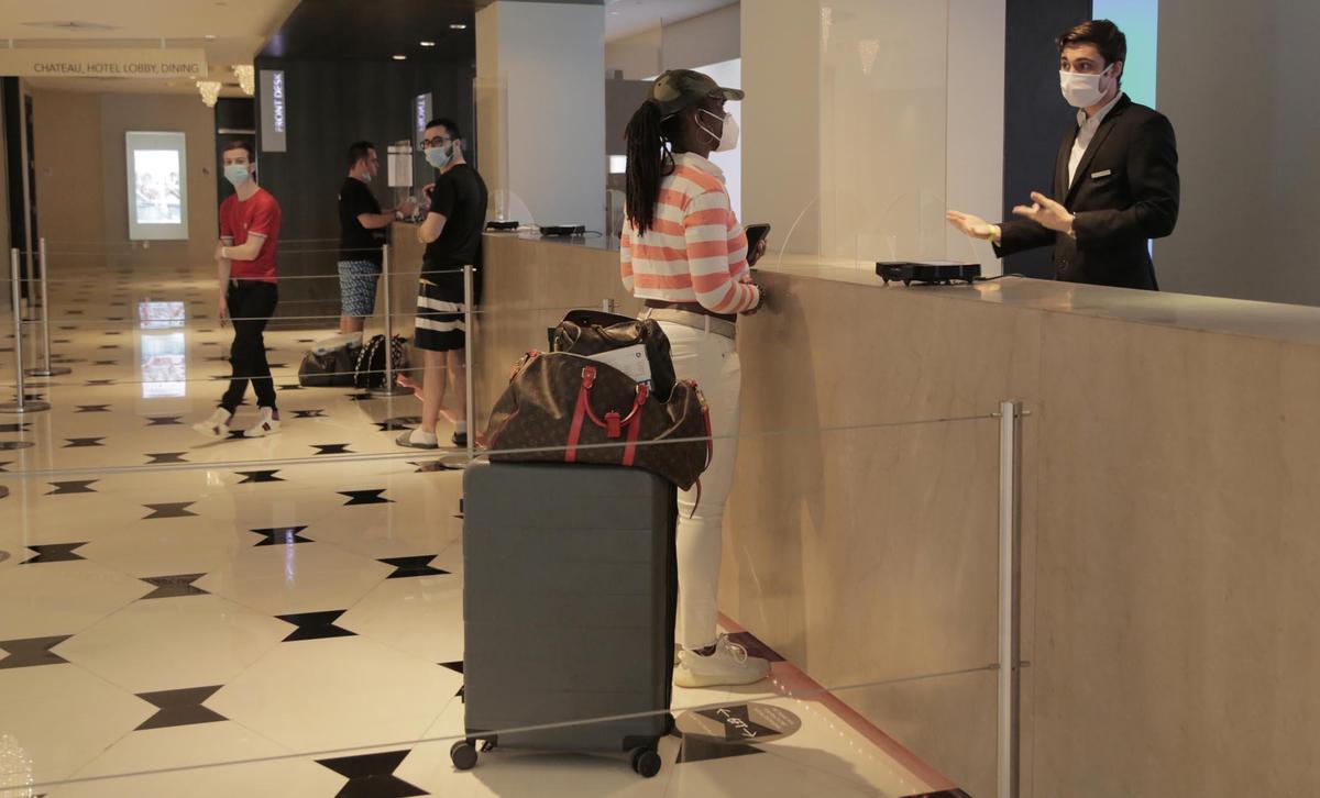 Miami Beach, Florida, June 1, 2020- Latoya Ruckner, from Detroit, Michigan, wearing the striped shirt, at the front desk checks in at the Fontainebleau Miami Beach.