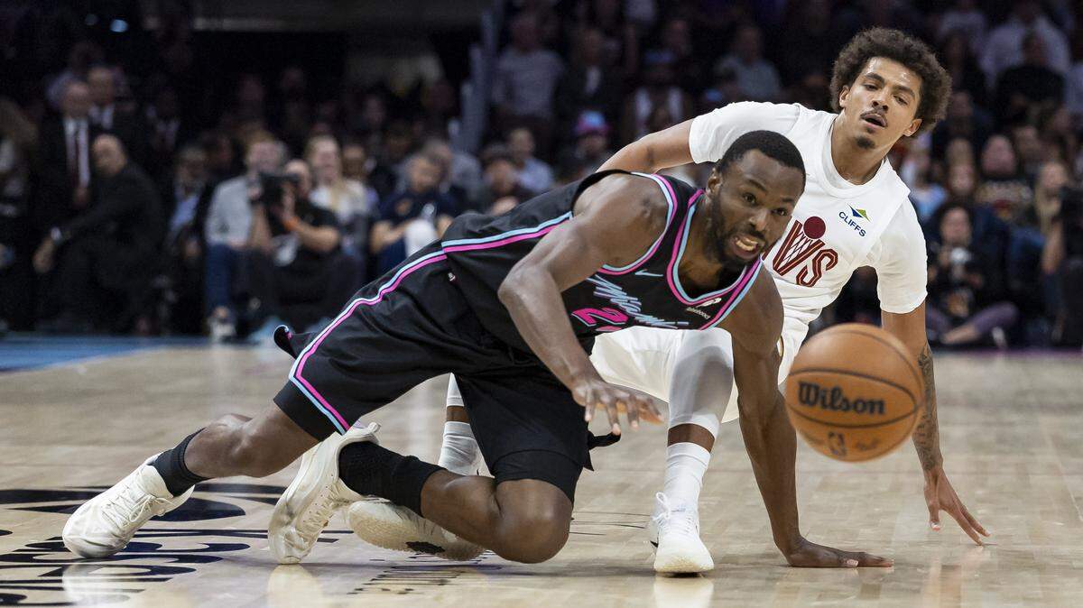 Miami Heat forward Andrew Wiggins (22) and Miami Heat guard Pelle Larsson (9) fight for the ball in the first half of their NBA game at the Kaseya Center on Nov. 12, 2025, in Miami.