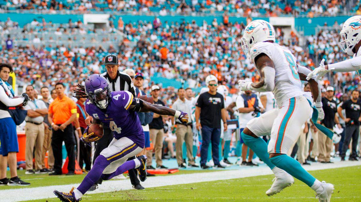 Minnesota Vikings running back Dalvin Cook (4) runs with the football against Miami Dolphins safety Jevon Holland (8) during fourth quarter of an NFL football game at Hard Rock Stadium on Sunday, October 16, 2022 in Miami Gardens, Florida.