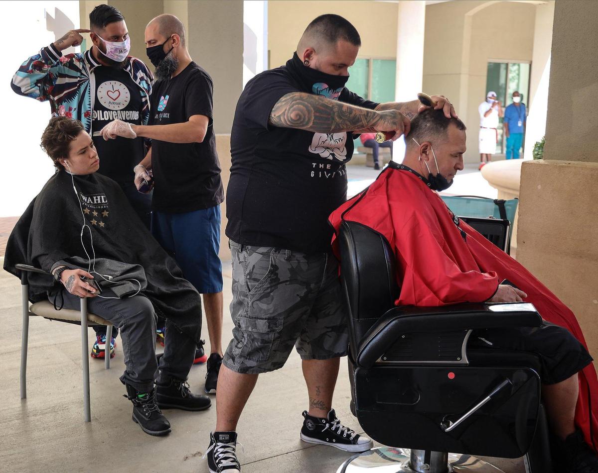 Razzeldazzle Barbershop and Miami Give Back barbers cut the hairs of clients. In celebration of the 60th annual Thanksgiving Day feast Camillus House limited the number of volunteers to 40 and requiring pre-event testing for those who have signed up to serve 300-plus people who live there, plus another 150 unsheltered homeless men and women in an open-air tent at the Norwegian Cruise Line Campus of Camillus House on Thanksgiving Day, November 26, 2020.