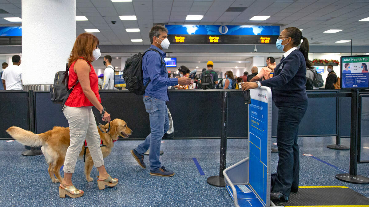 Viajeros con mascarillas pasan por el control de seguridad en el vestíbulo D del Aeropuerto Internacional de Miami, el 22 de noviembre de 2020, en Miami.