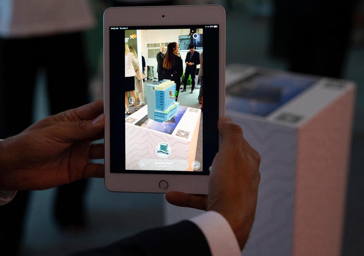 A attendee looks at an augmented reality scan of the building during a ceremony celebrating the $50 million donation by Ken Griffin, Citadel CEO, for a new building called the Kenneth C. Griffin Cancer Research Building on Tuesday, March 5, 2024, on the campus of the University of Miami Miller School of Medicine in Miami.