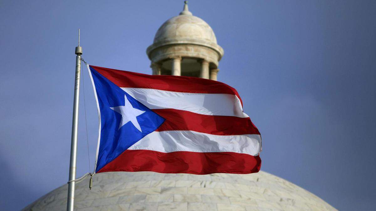The Puerto Rican flag flies in front of the Capitol building in San Juan.