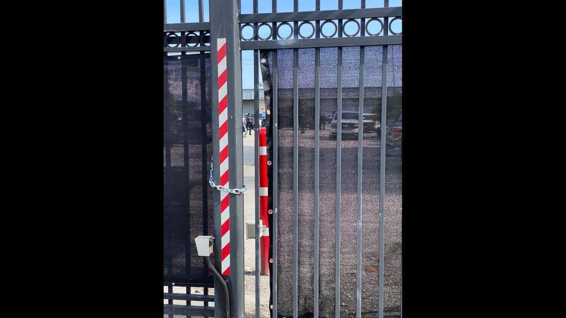 A riot squad waits in full crowd-control gear behind a fence at Fort Lauderdale police station. In front of the building, protesters chanted ‘No justice no peace.’