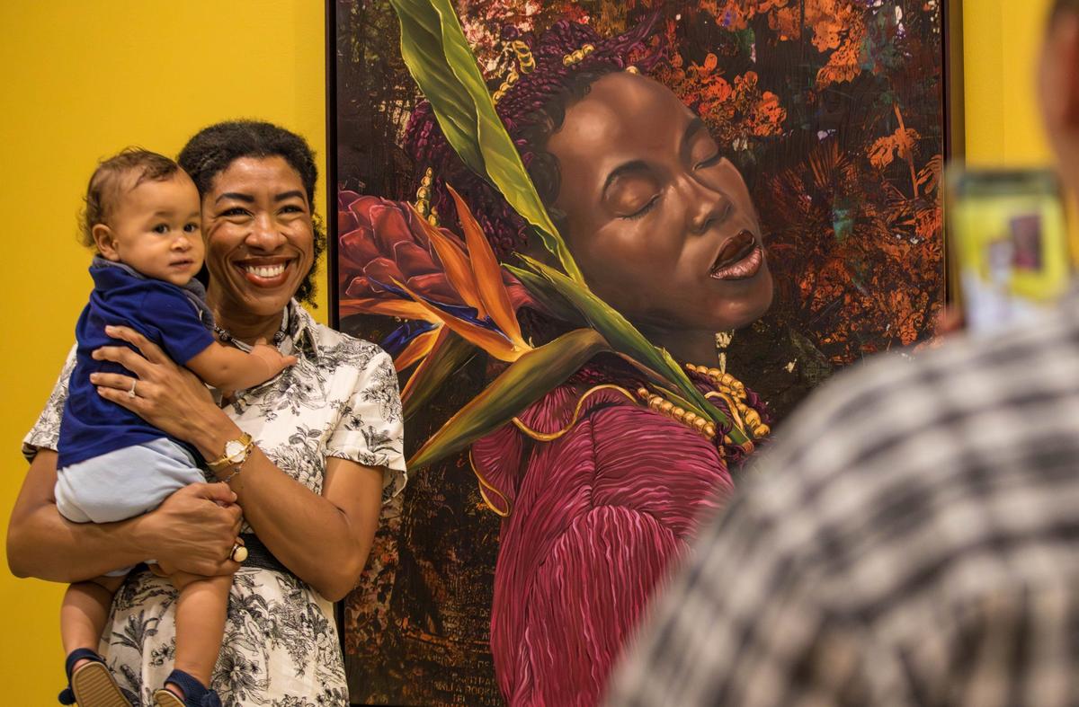 Angela Betancourt poses with her son Maximilian Hadley for a photo at Cornelius Tulloch’s solo show opening party at the Andrew Reed Gallery.