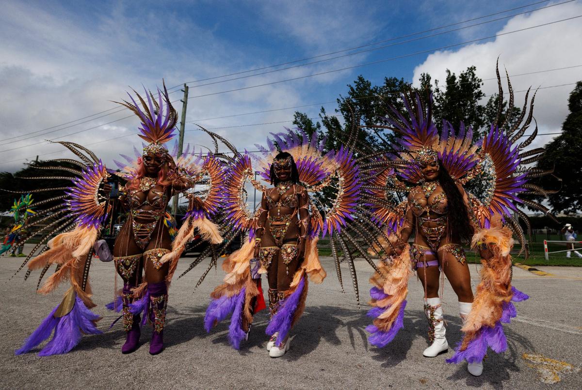 Three sisters masquerade before the Parade of Bands at Miami Carnival on Sunday, Oct. 13, 2024, at Miami-Dade County Fair Expo.