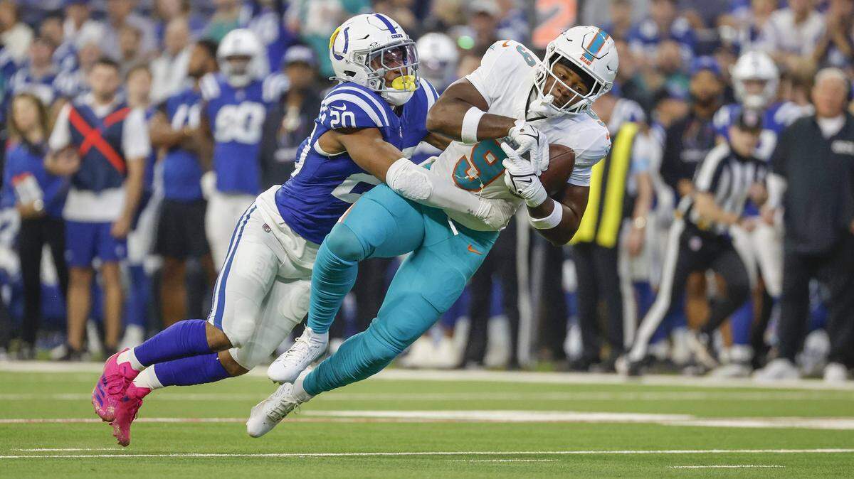Miami Dolphins tight end Jonnu Smith (9) catches a first down pass as Indianapolis Colts safety Nick Cross (20) defends in the first half during an NFL football game in Indianapolis, Indiana on Sunday, October 20, 2024.