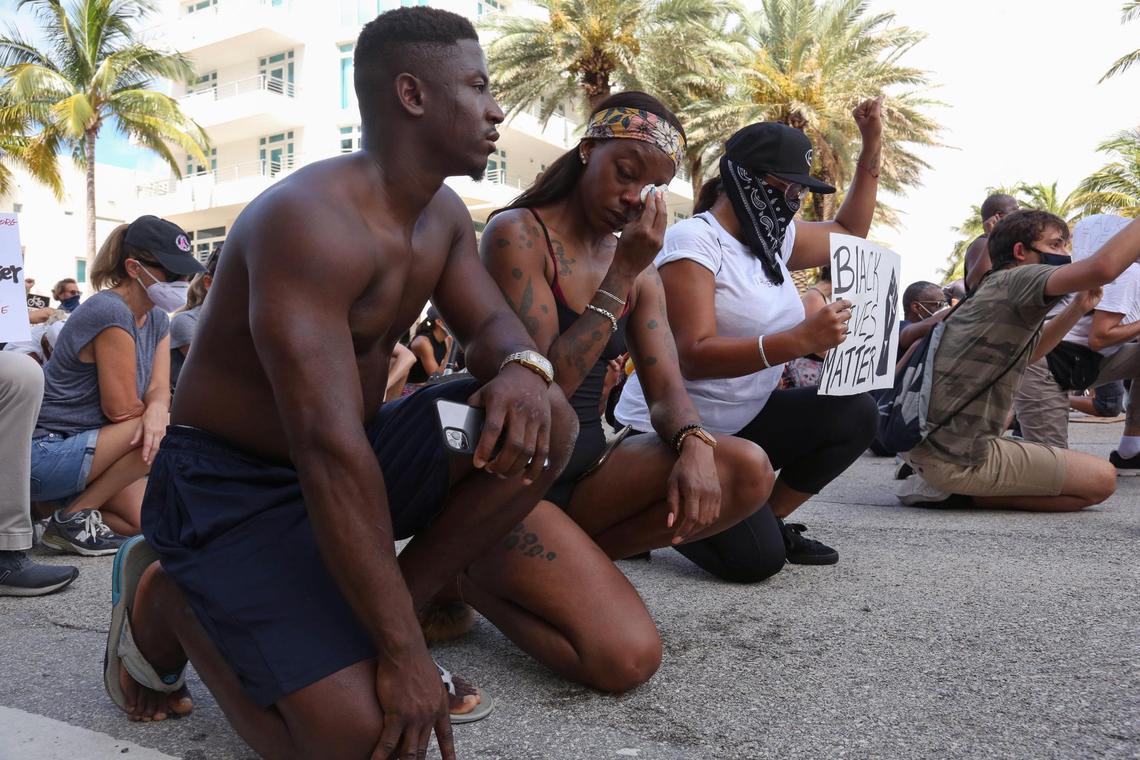 Shanta Pointer, 32, of Albany, New York, wipes off tears as she takes a knee for eight minutes on Fifth Street and Ocean Drive during a demonstration to support Black Lives Matter in Miami Beach on Sunday, June 14, 2020.