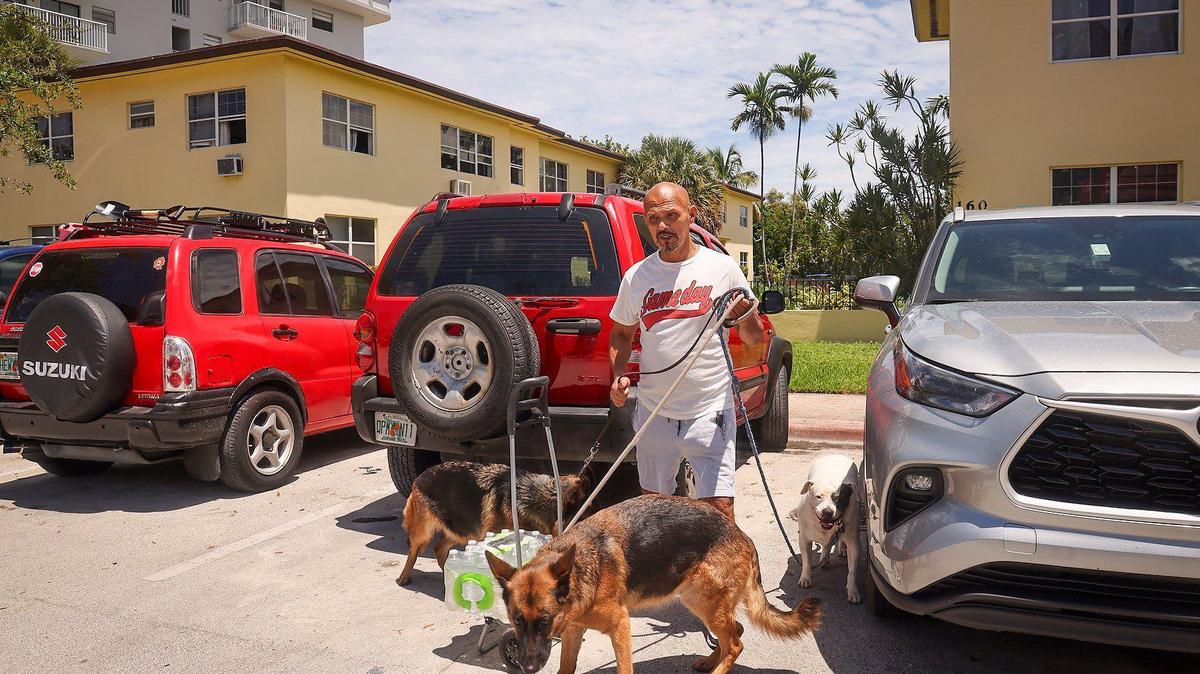 North Beach resident Pablo Mejia, 59, walks his dogs pass parked vehicles Monday, July 1, 2024. He could soon be part of a residential parking program for the first time in Normandy Shores.