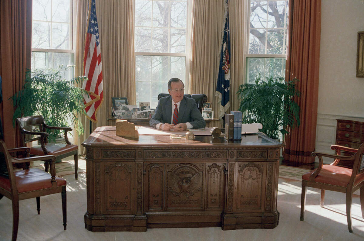 President George Bush is seen at work behind his desk in the Oval Office, 1989. (AP Photo)