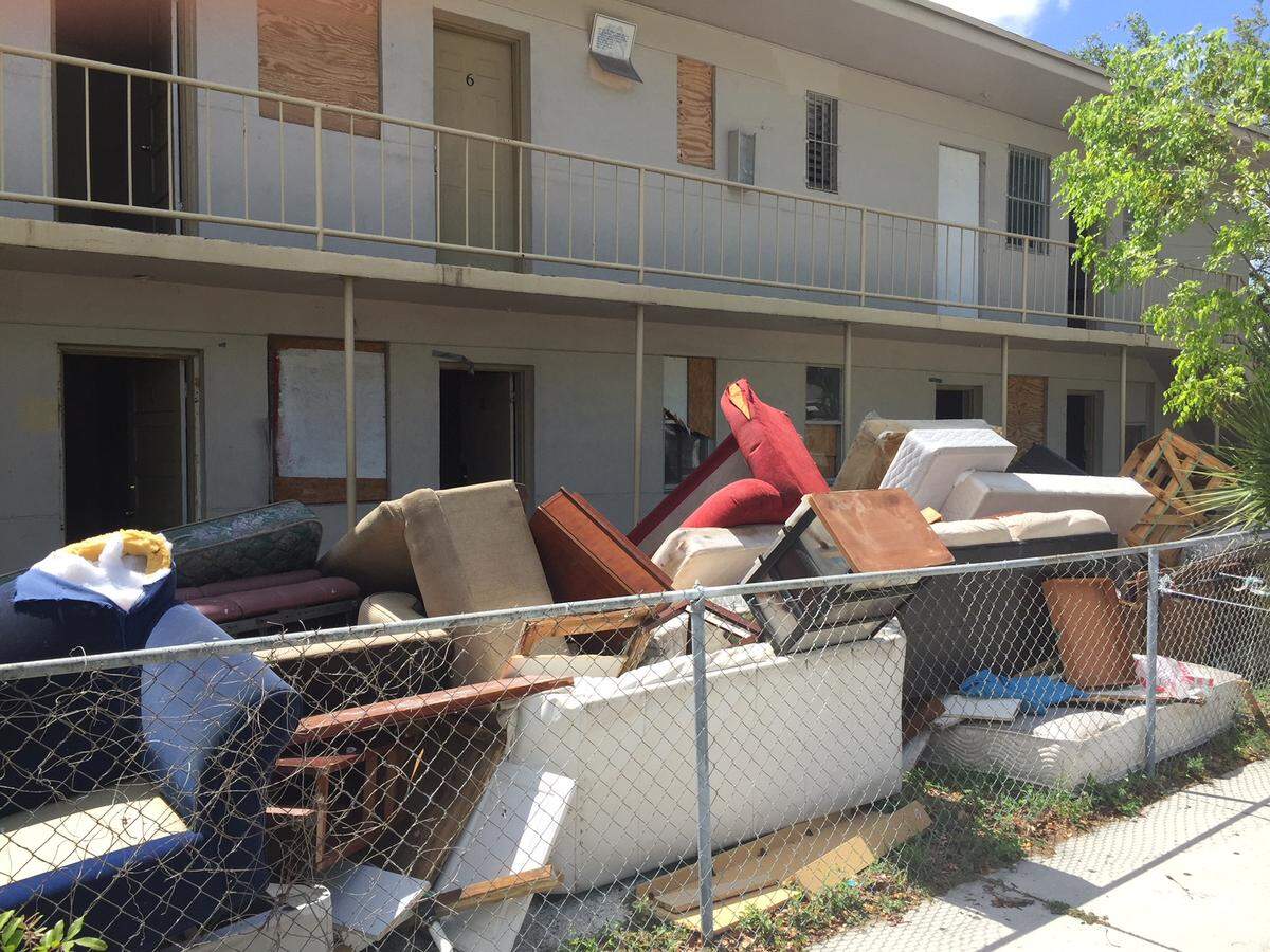 Evicted tenants’ discarded furniture fills the yard of an apartment building that was slated for demolition in May on Grand Avenue in West Coconut Grove.