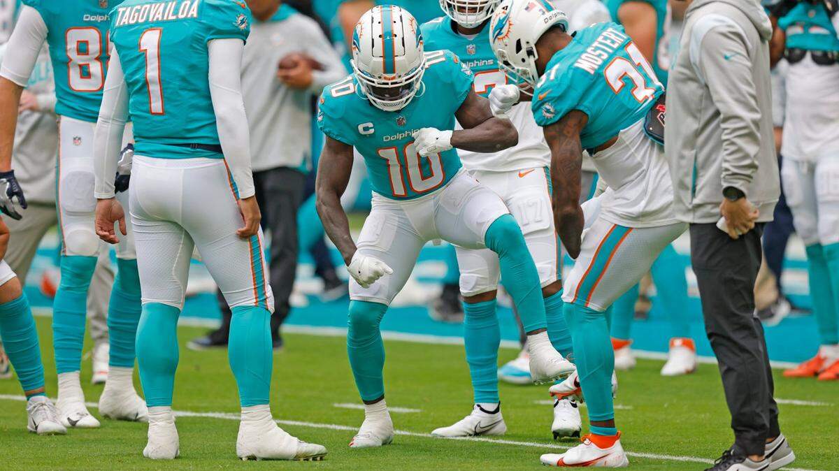 Miami Dolphins wide receiver Tyreek Hill (10) and running back Raheem Mostert (31) dance on the field with quarterback Tua Tagovailoa (1) and teammates before the start of the game against the Green Bay Packers at Hard Rock Stadium in Miami Gardens, Florida on Sunday, December 25, 2022.