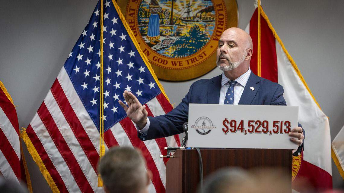Florida Chief Financial Officer Blaise Ingoglia holds a sign showing the amount of money he claims the city of Miami is overspending in its 2025 budget. Ingoglia spoke at a press conference at the Rohde Building in downtown Miami on Thursday, Oct. 23, 2025.