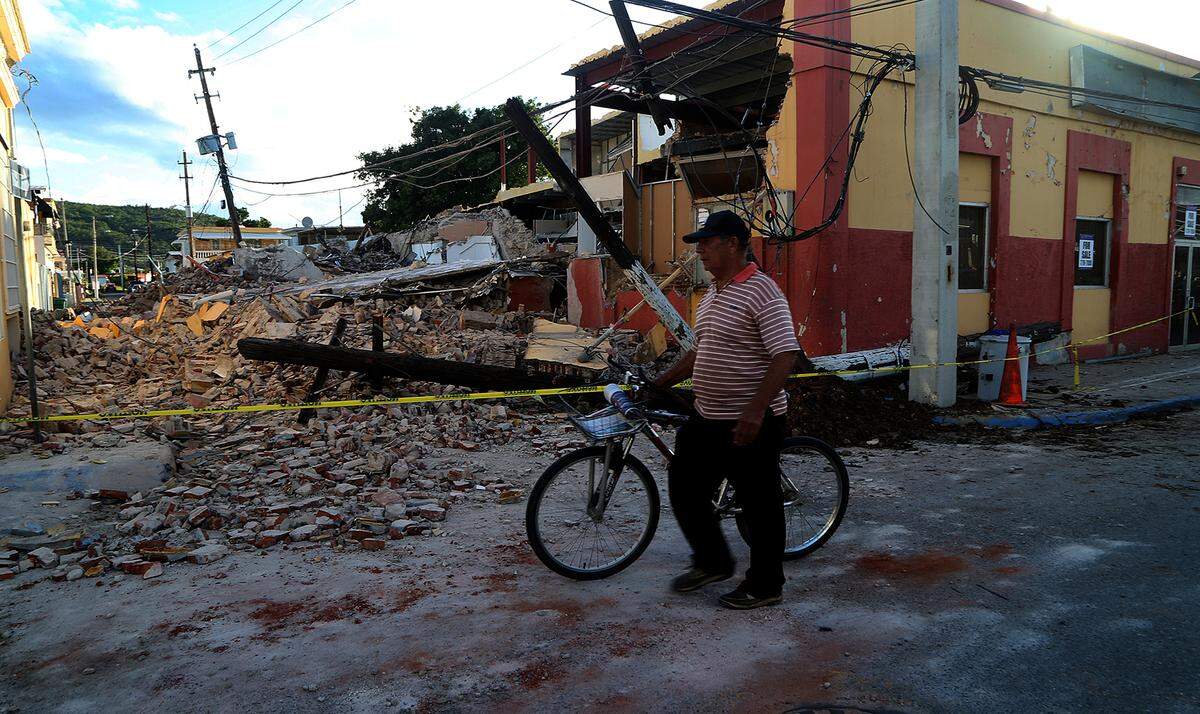 Un hombre pasa junto a un edificio dañado por el terremoto en el poblado de Guayanilla, en la costa sur de Puerto Rico, en una imagen del jueves 9 de enero de 2020.