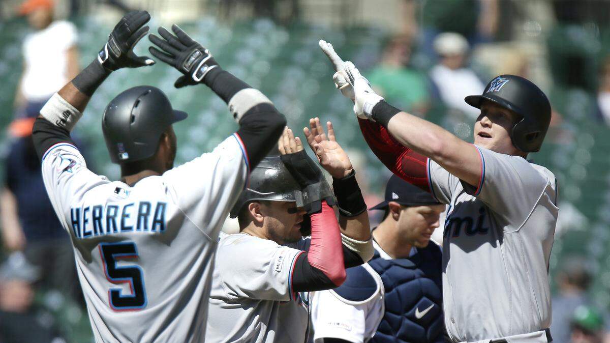 Garrett Cooper #26 of the Miami Marlins, right, celebrates his grand slam against the Detroit Tigers with Rosell Herrera #5 and Miguel Rojas #19 during the ninth inning at Comerica Park on May 23, 2019 in Detroit, Mich. The Marlins won, 5-2. (Duane Burleson/Getty Images/TNS)