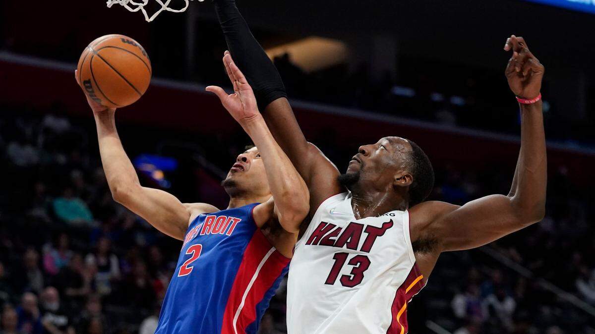El escolta de los Pistons, Cade Cunningham (2), intenta una bandeja mientras el centro del Heat, Bam Adebayo (13), defiende en un juego de la NBA, est martes 23 de noviembre de 2021, en Detroit.