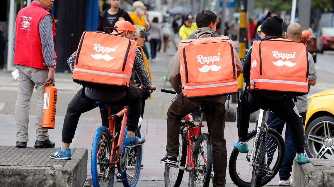 Venezuelan nationals working as bicycle couriers for the Colombian online delivery company Rappi ride their bikes in Bogota on October 11, 2018.