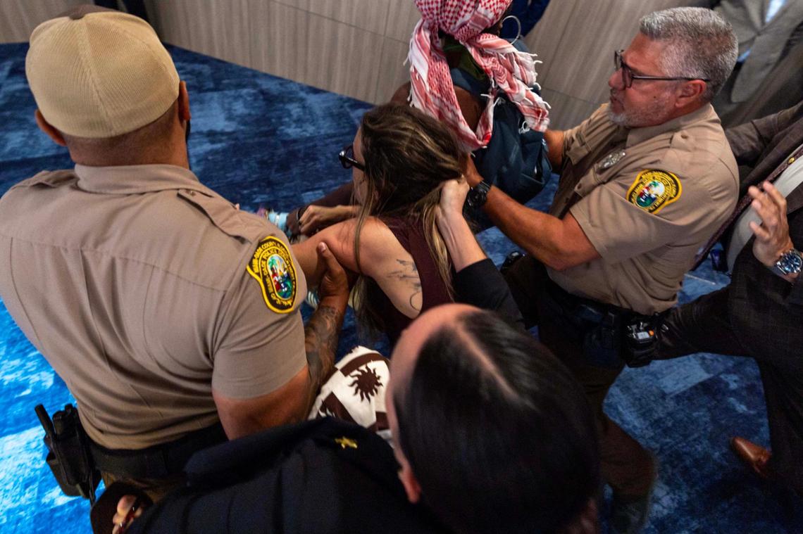 Camila Ramos is forcibly removed from the commission chambers by officers during a Miami-Dade County Commission meeting at the Stephen P. Clark Government Center on Thursday, June 26, 2025, in Miami.