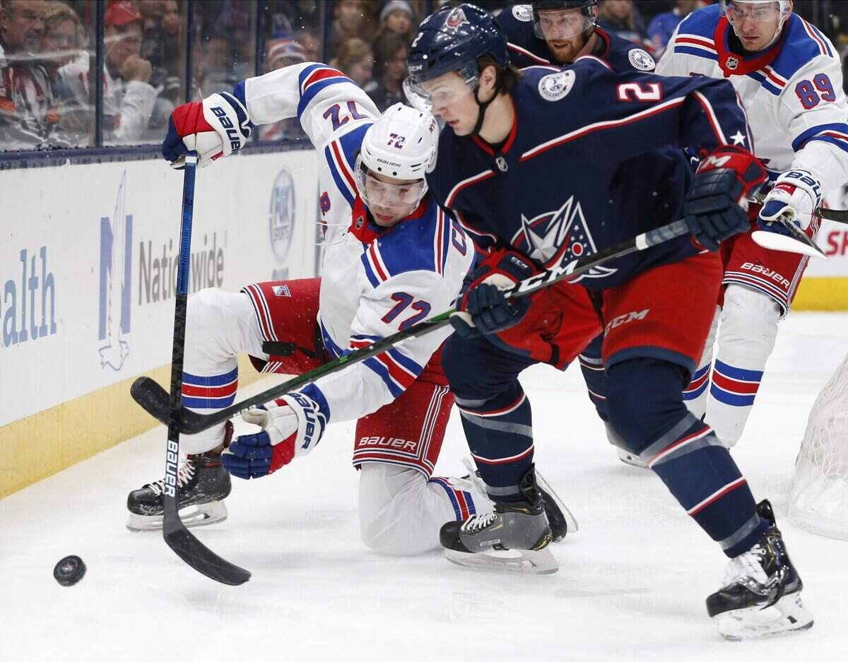 New York Rangers’ Filip Chytil, left, of the Czech Republic, and Columbus Blue Jackets’ Andrew Peeke fight for the puck during the first period of an NHL hockey game Thursday, Dec. 5, 2019, in Columbus, Ohio. (AP Photo/Jay LaPrete)
