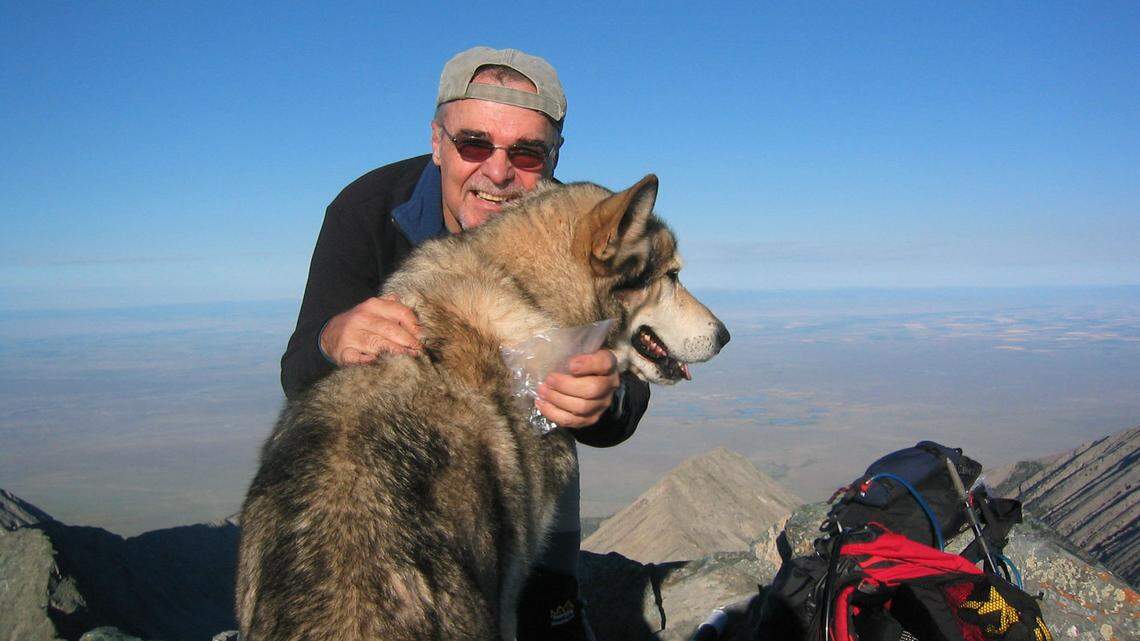 Denali, a wolf belonging to guide Michael Covington, and John Rothchild atop Little Bear in Colorado. Rothchild passed away Thursday at the age of 79. 