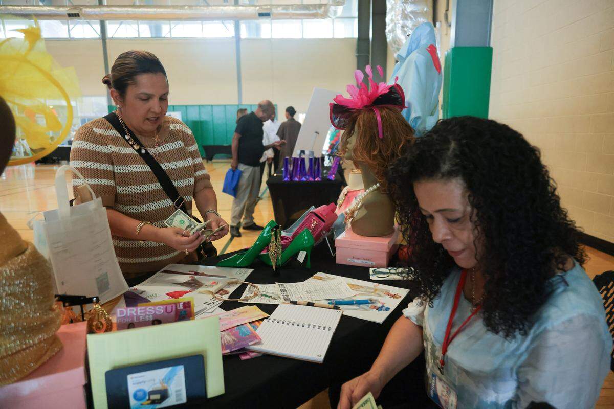 Lizabeth Miguel, 46, purchases a neckless from Cecilia Orrero, a store manager at Dress U For Less in North Miami, during the City of North Miami District 4 Small Business Expo at the Joe Celestin Center at 1525 NW 135th St. in North Miami, Florida, Friday, August 22, 2025.