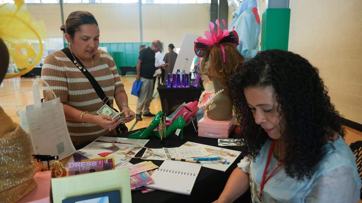 Lizabeth Miguel, 46, purchases a neckless from Cecilia Orrero, a store manager at Dress U For Less in North Miami, during the City of North Miami District 4 Small Business Expo at the Joe Celestin Center at 1525 NW 135th St. in North Miami, Florida, Friday, August 22, 2025.